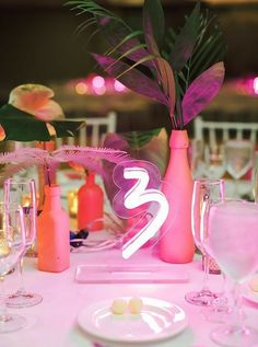 the table is set with pink flowers and candles