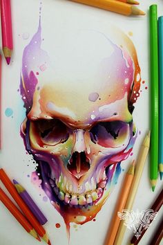 a drawing of a skull with colored pencils next to it