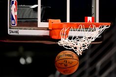 a basketball is being dunked into the hoop by an orange and white team logo