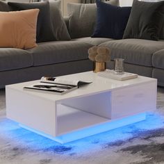 a white coffee table with blue lights on it in the middle of a living room