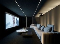 a long couch sitting next to a white table in a living room under a flat screen tv