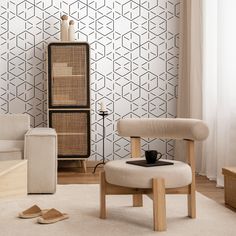 a living room with two chairs and a coffee table in front of a patterned wall