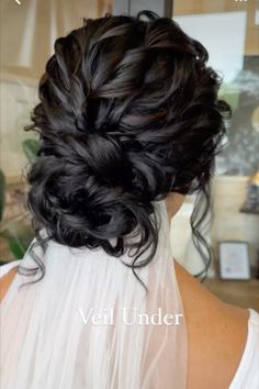 the back of a woman's head with black hair in a low updo