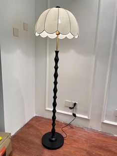 a floor lamp sitting on top of a hard wood floor