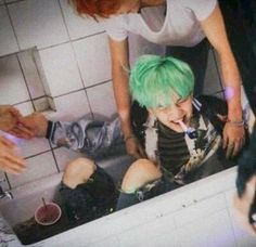 a person with green hair sitting in a bath tub