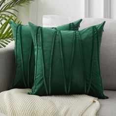 two green pillows sitting on top of a couch