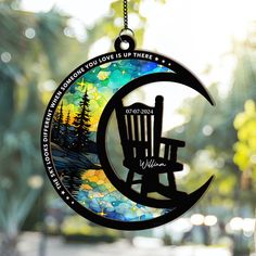 a glass ornament with a chair on the moon and trees in the background