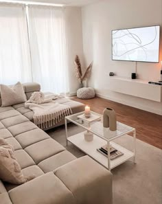 a living room filled with furniture and a flat screen tv mounted on the wall above it