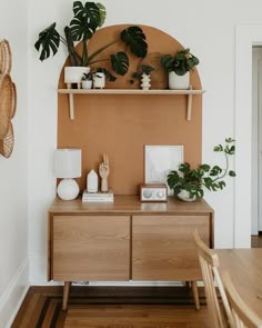 a wooden table topped with potted plants next to a wall mounted shelf