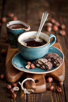 two cups of coffee and some cookies on a wooden table