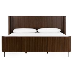 the bed has two pillows on it and is made up with wooden slatted headboard