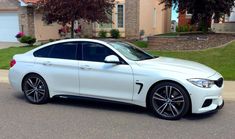 a white car parked in front of a house