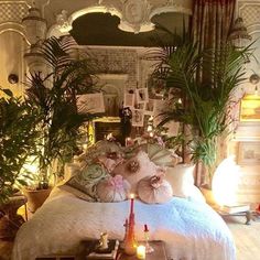 a bedroom with plants and candles on the bed