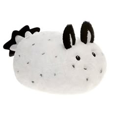 a white and black stuffed animal with horns on it's head, sitting in front of a white background