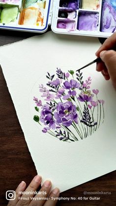 someone is painting flowers with watercolors on paper