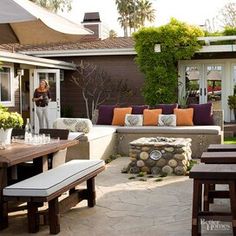 a woman is standing in the back yard with an outdoor seating area and fire pit