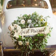 a wedding car decorated with flowers and a sign that says just married on the front