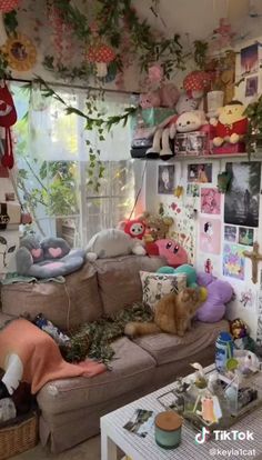 a living room filled with furniture and lots of stuffed animals hanging from the ceiling above