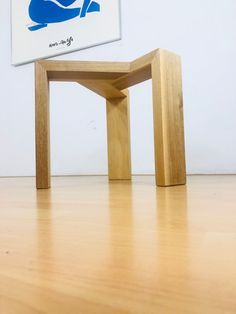 a wooden table sitting on top of a hard wood floor next to a white wall