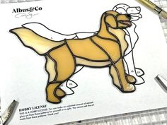 a drawing of a brown dog on top of a piece of paper with scissors next to it