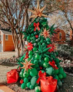 a christmas tree made out of balloons and starbursts in front of a house