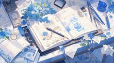 an open book sitting on top of a table covered in blue flowers and other items