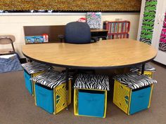 a table with four blue bins and zebra print chairs around it in an office