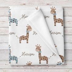 a baby blanket with giraffes and name on it