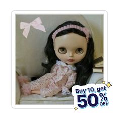 a doll with long hair sitting in a chair next to a sign that says buy 10 get 50 % off