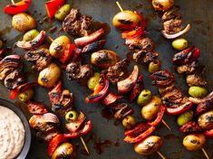 meat and vegetables on skewers with dip