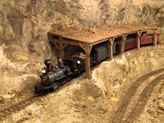 a toy train is coming out of a tunnel