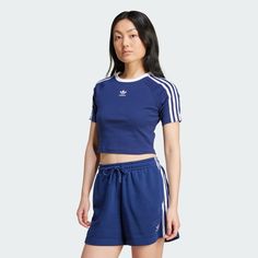 a woman in blue shorts and adidas t - shirt