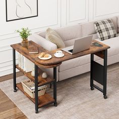 a laptop computer sitting on top of a wooden table next to a couch in a living room