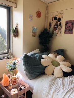 a room with a bed, flower pillow and other items on the table in front of it