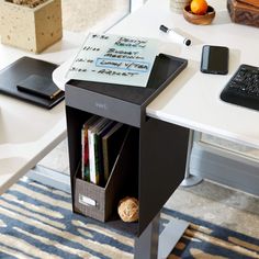 a computer desk with a keyboard, mouse and cell phone on it's side