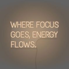 there is a neon sign that says where focus goes, energy flows