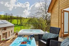 a hot tub sitting on top of a patio next to a table with fruit in it