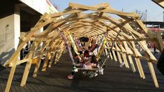 a group of people standing under a wooden structure