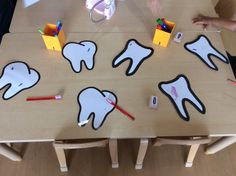 a child's table with toothbrushes, pencils and markers on it