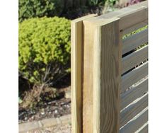 a close up of a wooden bench near bushes