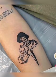 a person with a tattoo on their arm holding a knife