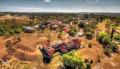 an aerial view of a large building in the middle of a field with lots of trees