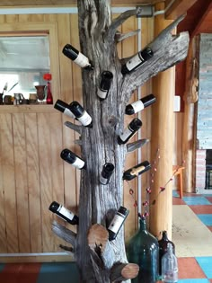 a tree with wine bottles on it in a room