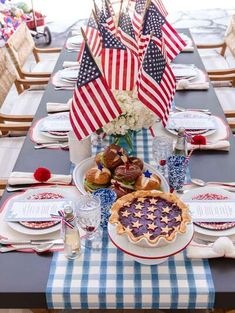 a patriotic table setting with an american flag centerpiece, pie and water glasses on the table