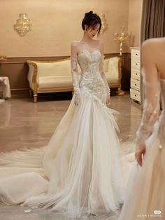 a woman in a wedding dress is looking at another woman's reflection in the mirror