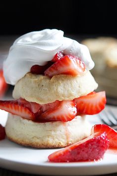 strawberry shortcakes with whipped cream and fresh strawberries on the side, ready to be eaten