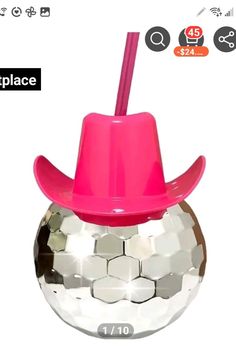 a pink hat on top of a disco ball with a straw sticking out of it