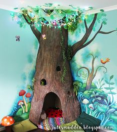 a child's bedroom with a tree trunk and fairy lights on the ceiling above it