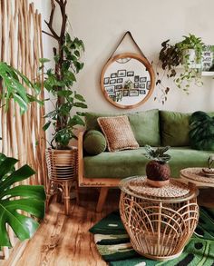 a living room filled with lots of green furniture and plants on top of wooden floors