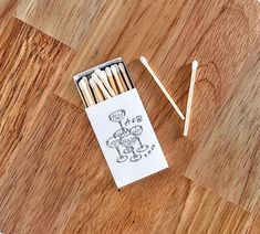 matches are sitting on the floor next to an envelope with a cartoon drawn on it